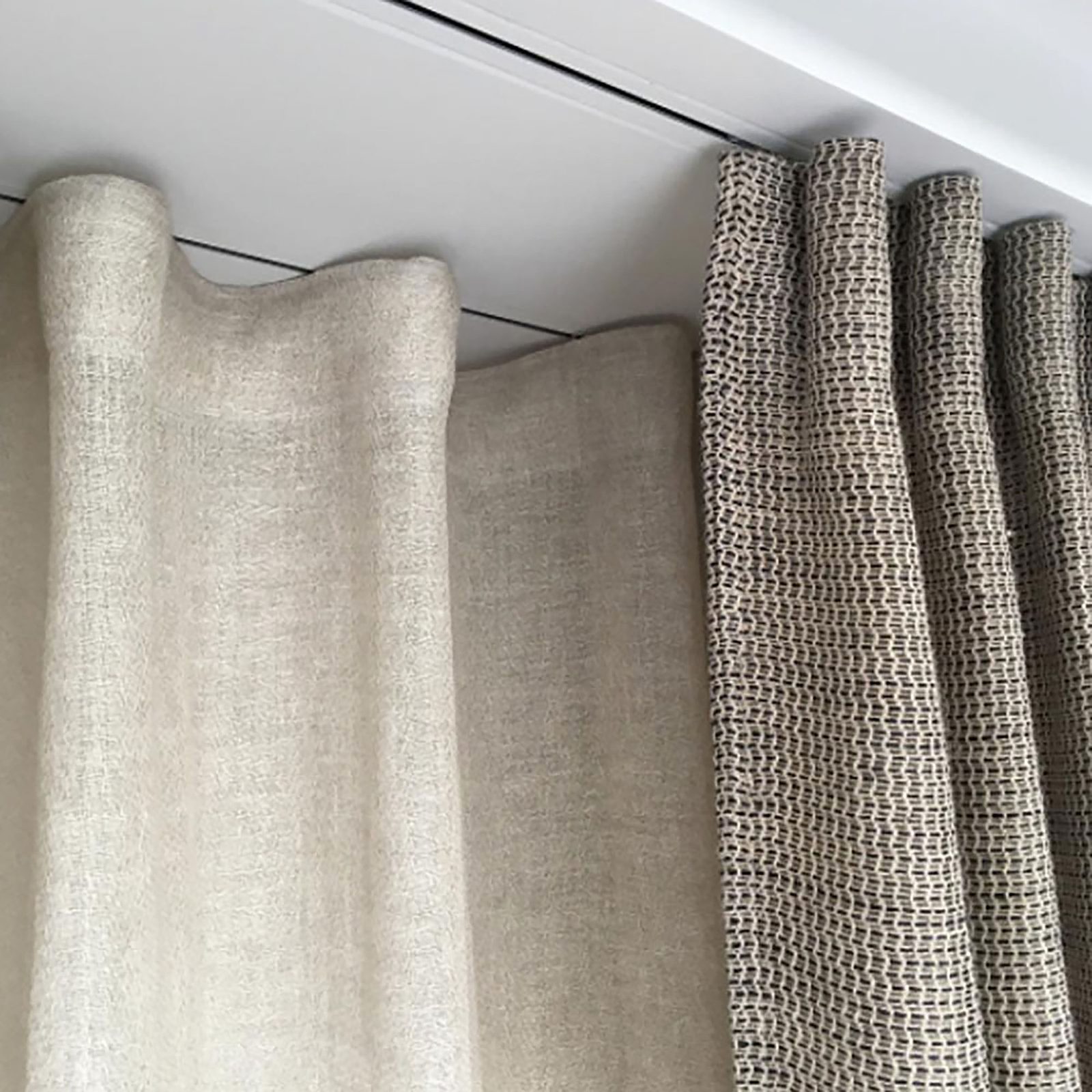 Linen drapery hanging from a recessed ceiling curtain track with no visible hardware