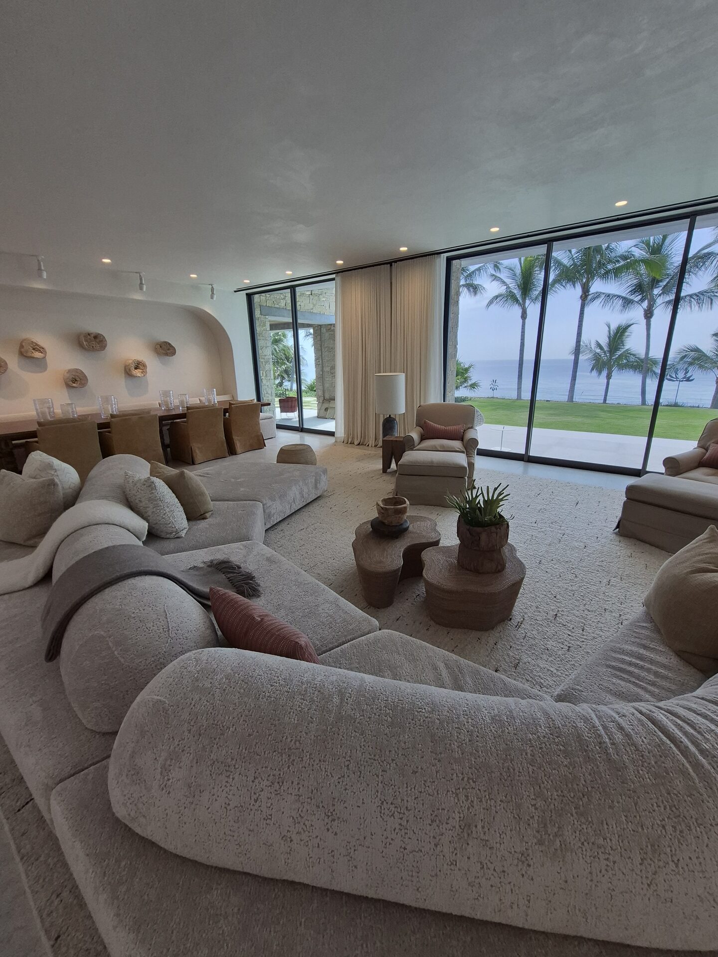 Floor-to-ceiling sheer draperies on a wall of sliding glass doors facing the ocean, South Florida