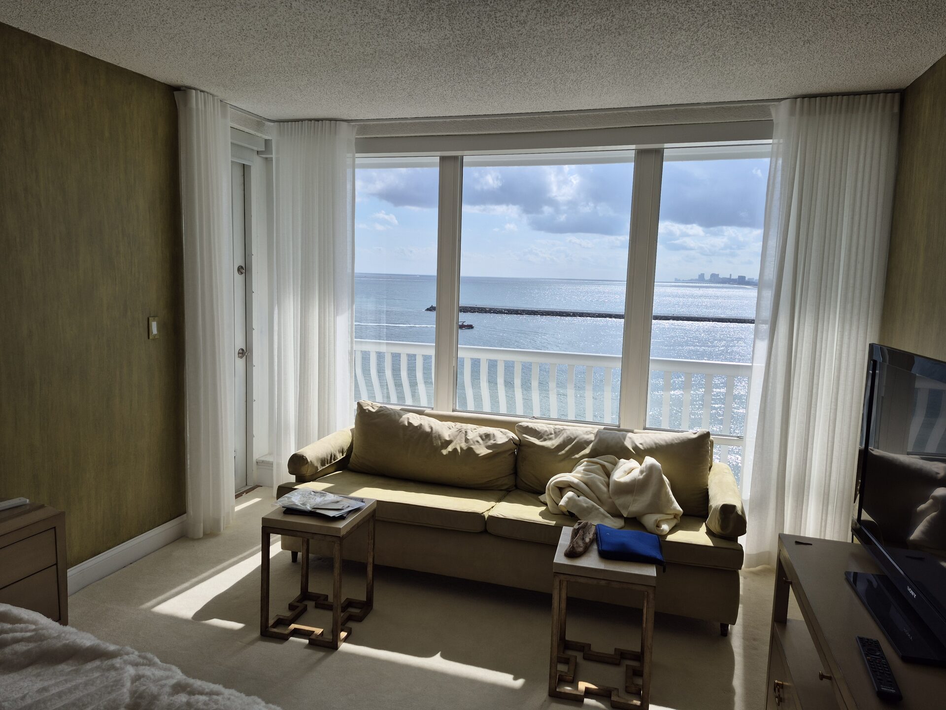 Sheer draperies on a sliding glass door opening to an oceanfront balcony