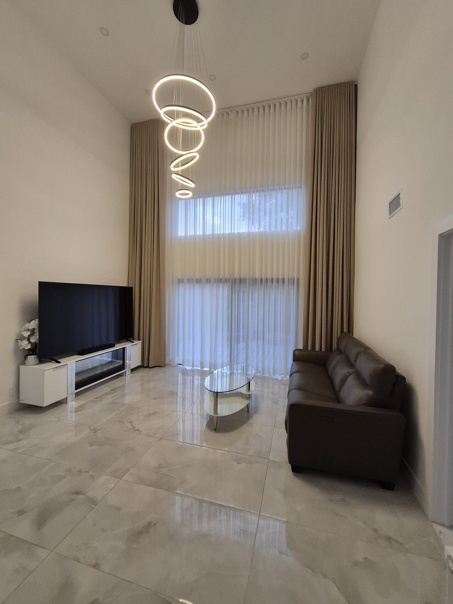 Two-story motorized drapes and sheers in a double-height living room