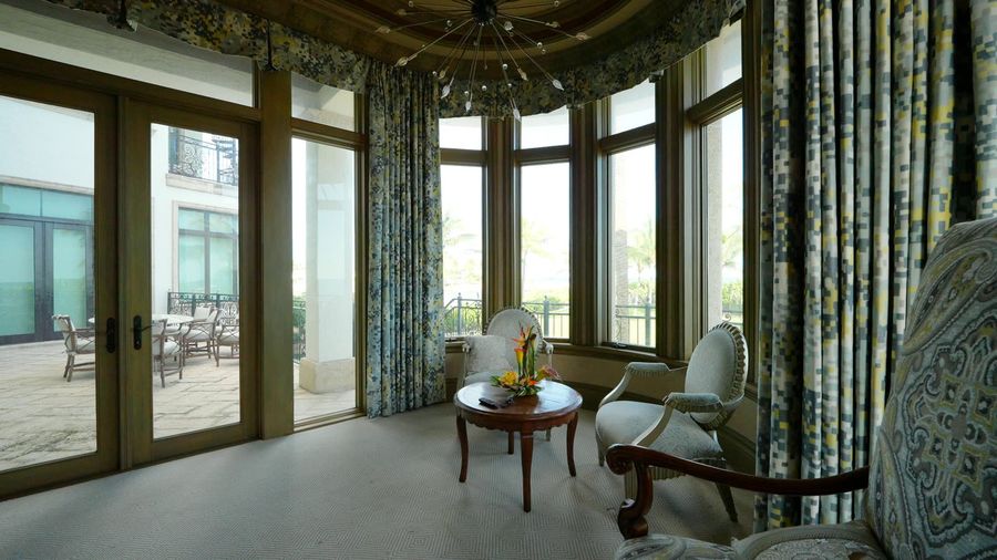 Bay window sitting area with Kravet Design 34697-521 drapery panels, motorized blackout shades raised, terrace beyond, Pompano Beach