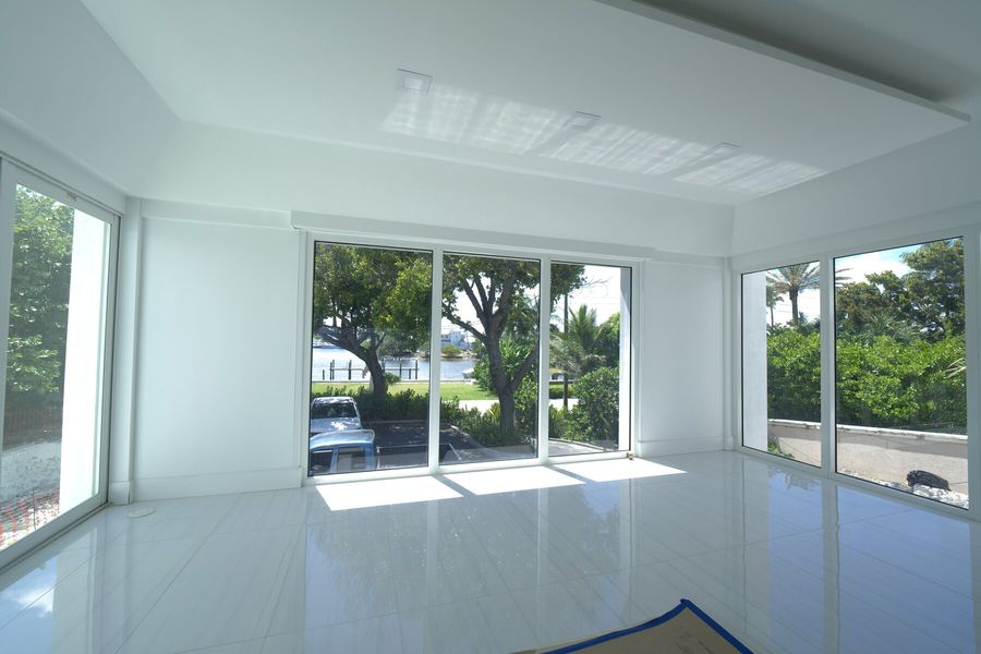 Street-side room with motorized shades pocketed above the glass, Hillsboro Beach