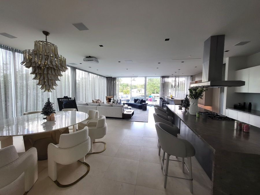 Dining and kitchen area with sheer draperies and a sculptural chandelier, Miami Beach