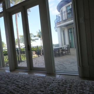 Tall French doors to a terrace with a motorized blackout shade raised, Pompano Beach