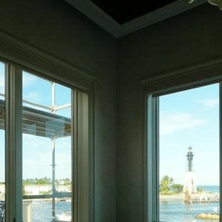 Picture window looking at the Hillsboro Inlet lighthouse with a motorized blackout shade starting down, Pompano Beach