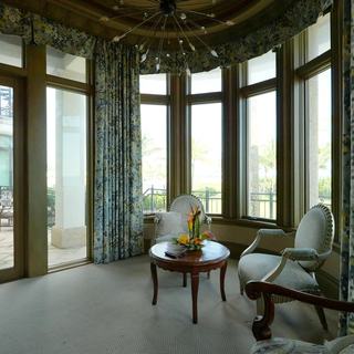 Bay window sitting area with Kravet Design 34697-521 drapery panels, motorized blackout shades raised, terrace beyond, Pompano Beach
