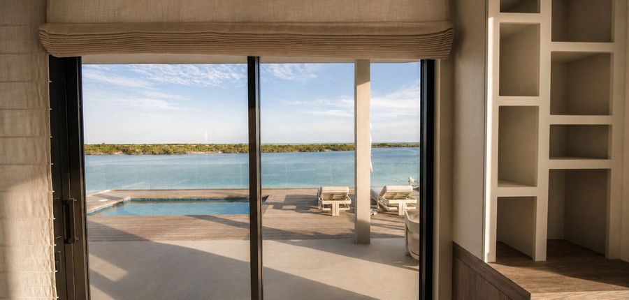 Villa living room with Lutron blackout shades overlooking the pool and ocean, Big Ambergris Cay, Turks and Caicos