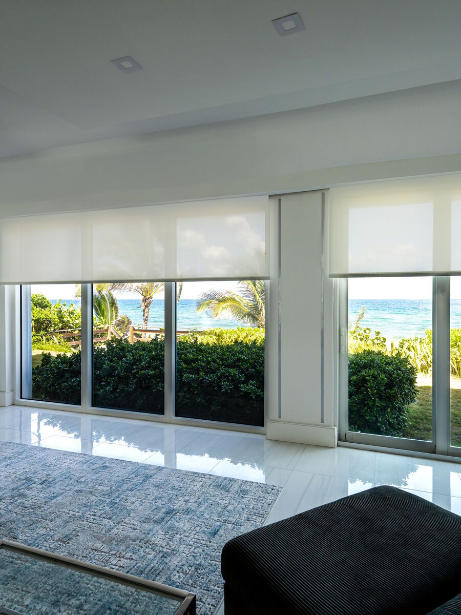 Solar roller shades over the oceanfront glass of a living room