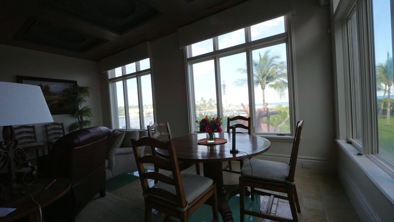 Breakfast nook with a round table, motorized shades up on the palms and the inlet