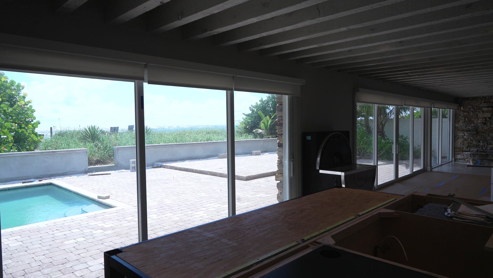 Family room sliders opening to the pool deck with the SheerWeave 4000 Eco screens raised