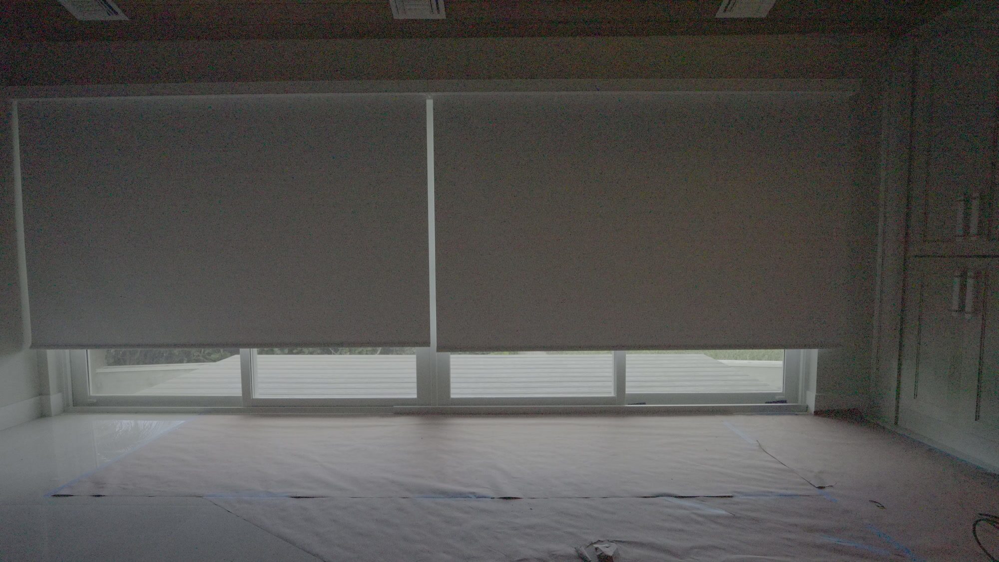 Primary suite bedroom with the SheerWeave 7200R Swan blackout shade lowered across the sliding glass