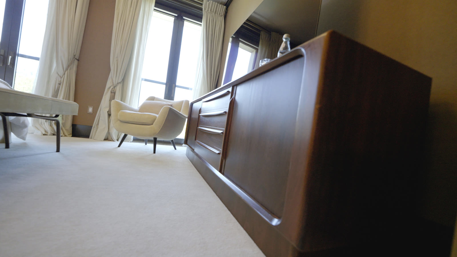 Styled bedroom with bench and armchair in the Central Park light