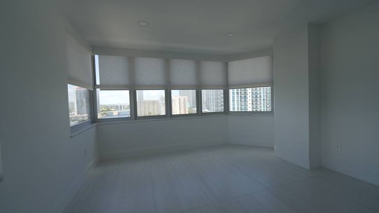 The living room with every Elba Daylight shade down, the room glowing in filtered light