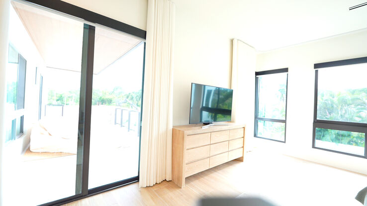 Master bedroom terrace slider and windows with the Lutron Triathlon rollers up and the drapery stacked clear of the glass