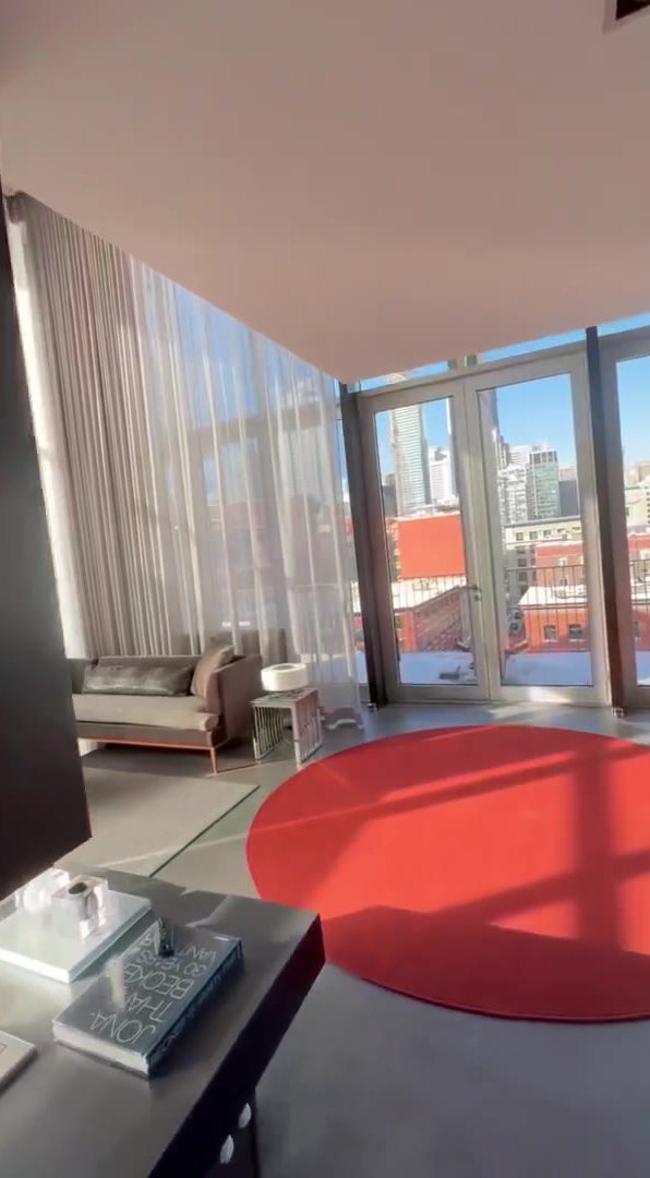 Double-height living room in an Old Port Montreal penthouse with sheers on Somfy Glydea motorized tracks