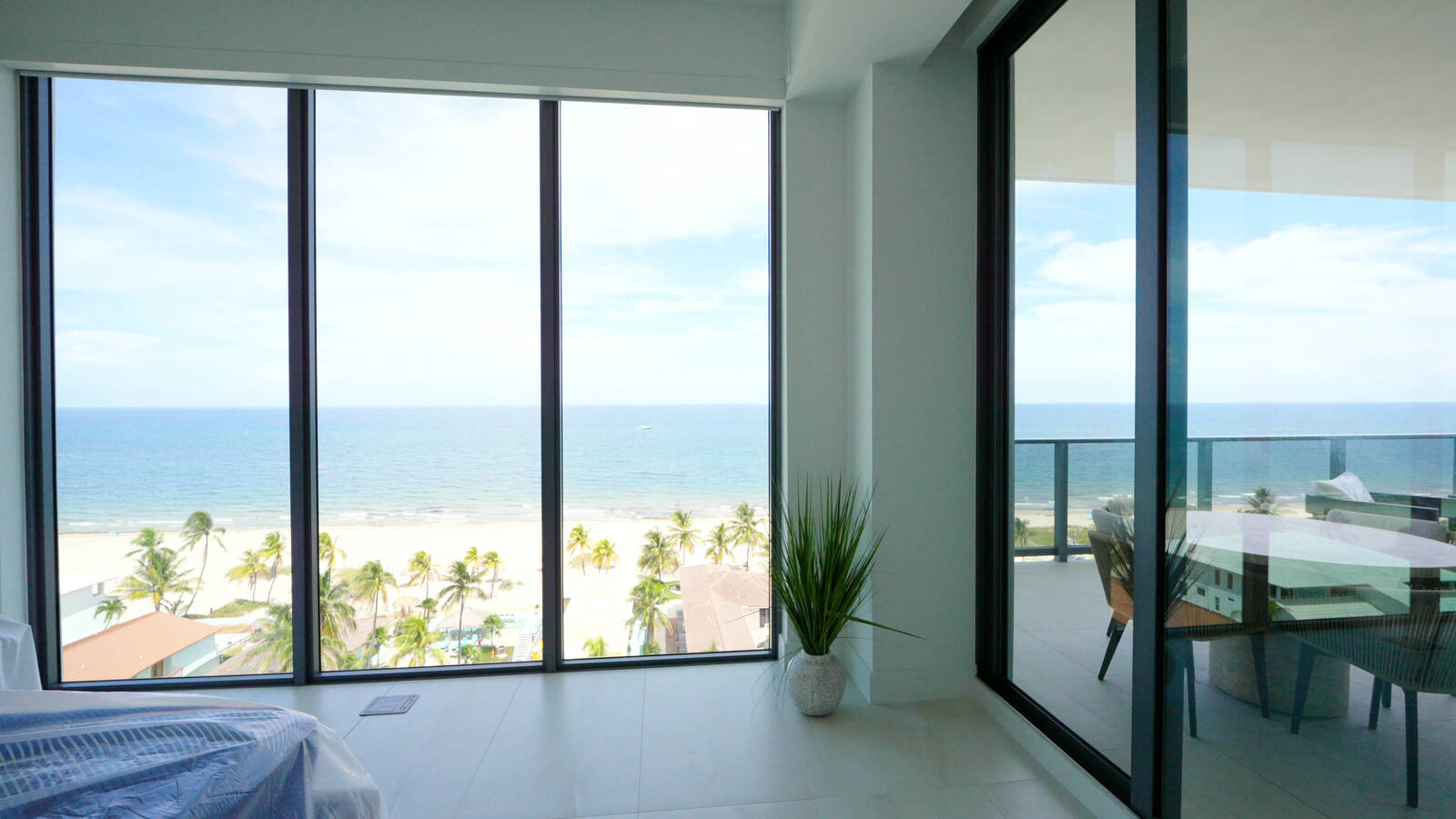Salato Pompano Beach master bedroom corner glass with Somfy motorized screens and the ocean beyond
