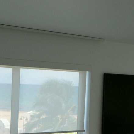 Paris 3% solar screen in Blanc with the beach visible through it