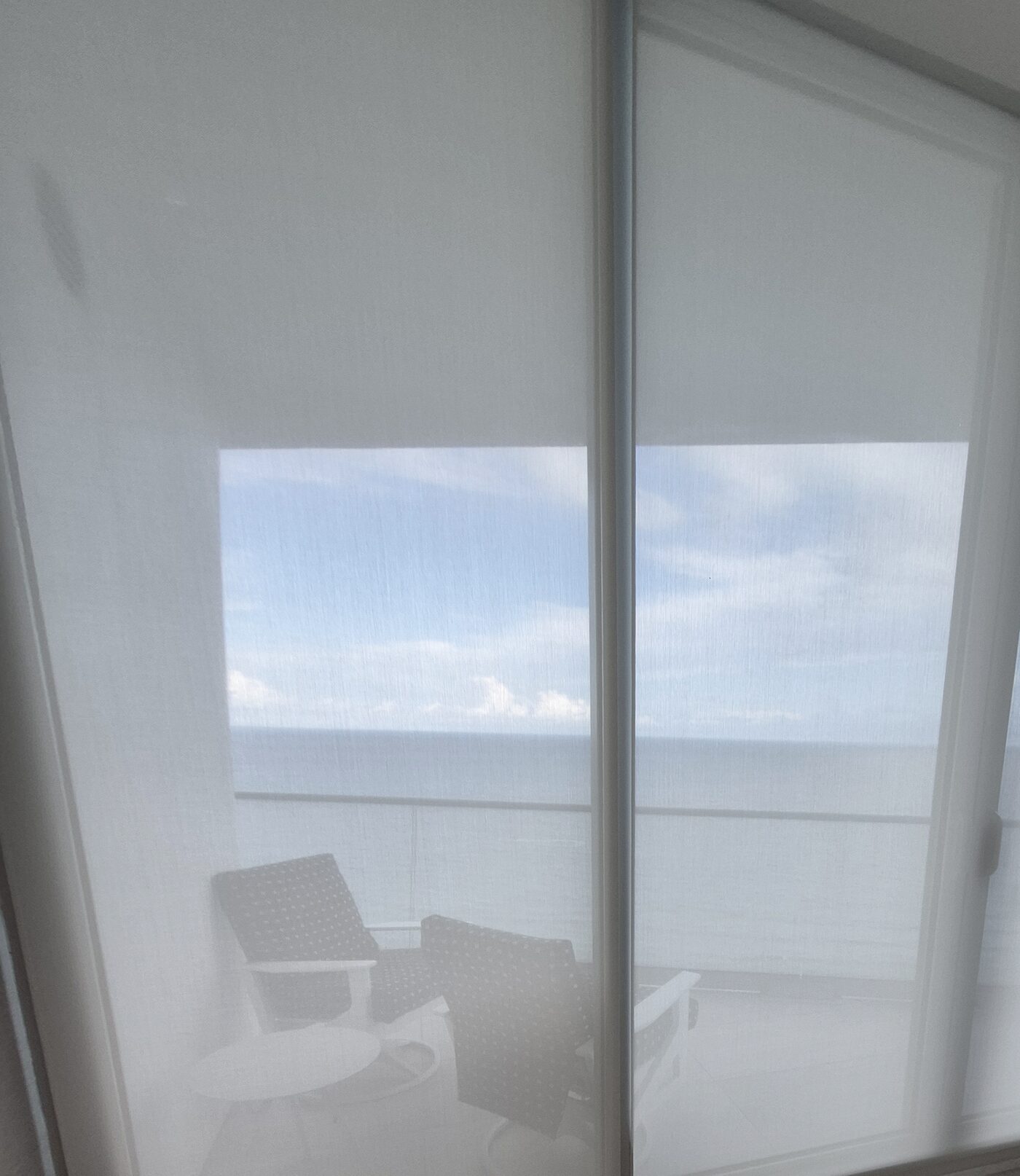 Solar screens on the terrace slider with patio furniture reading through the fabric