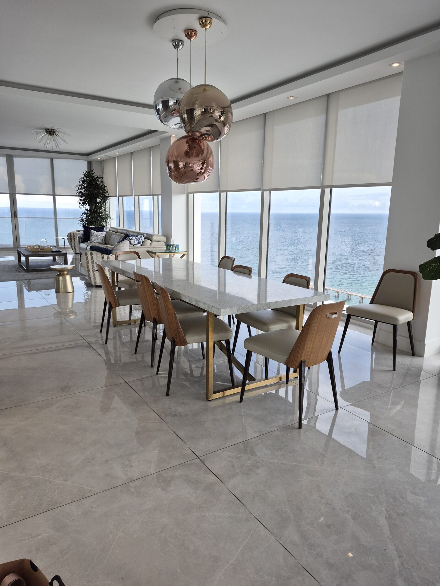 Dining room with the run of Crestron solar shades lowered across the ocean wall