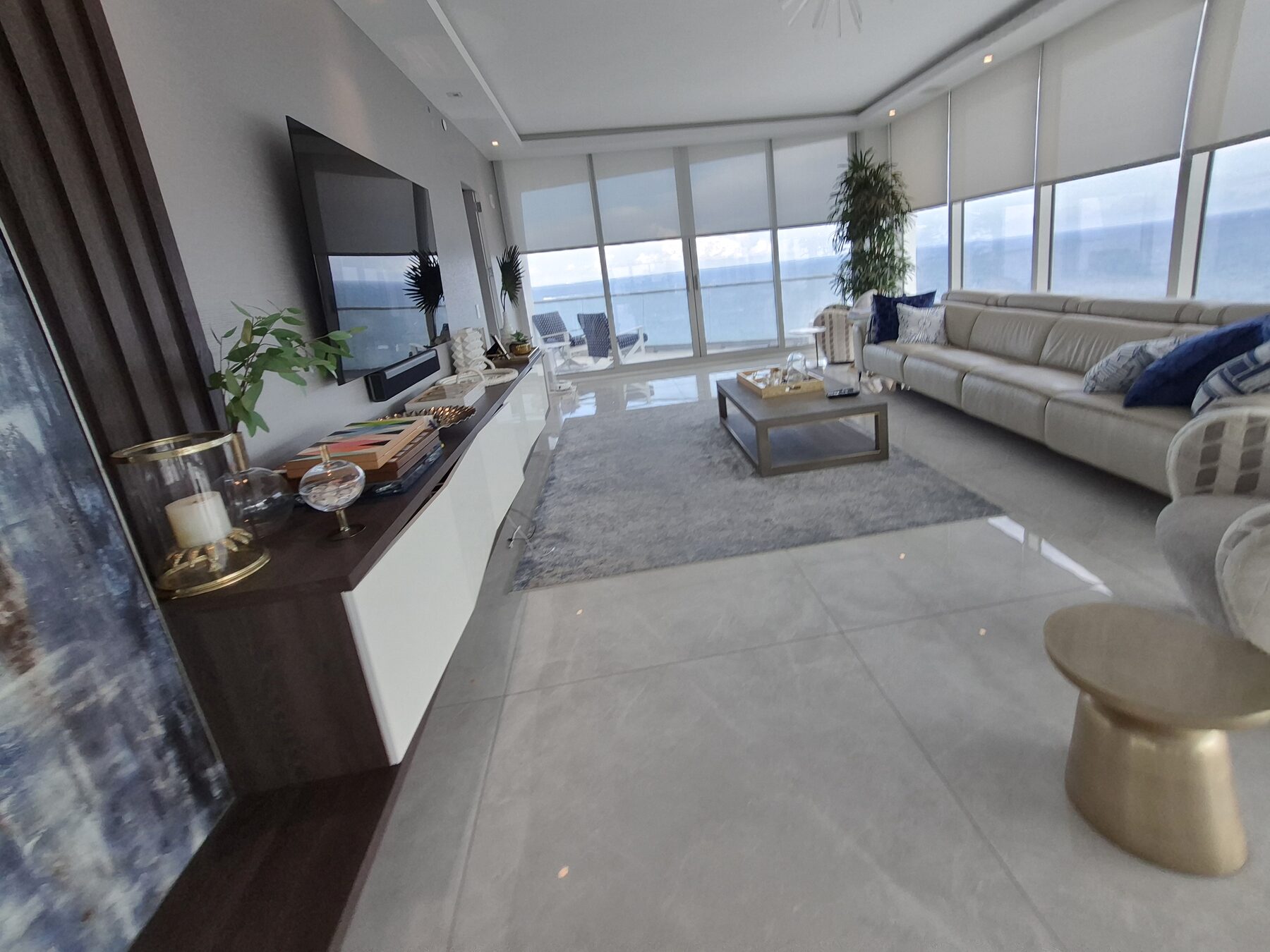Living room built-in and television with solar shades filtering the Atlantic light