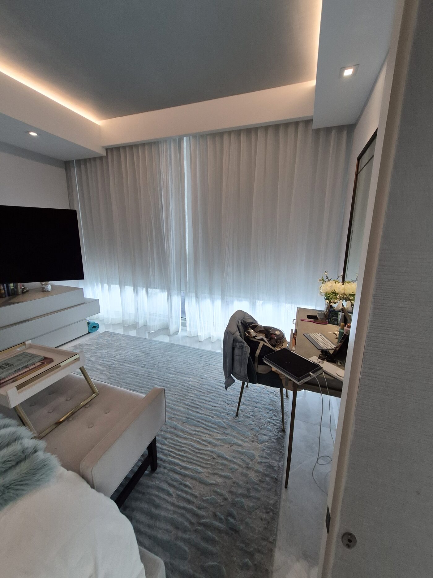 Primary suite with a white Fabricut sheer on a recessed Crestron motorized drapery track