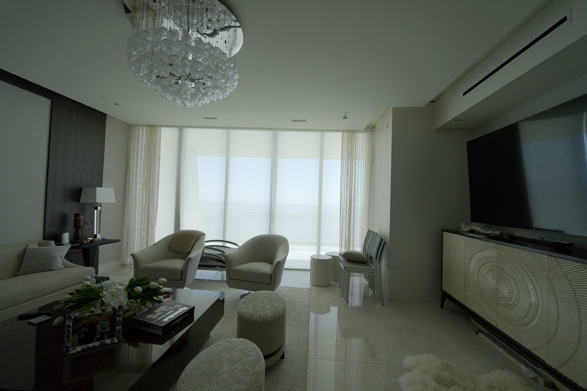 Living room with motorized E-Screen solar shades lowered over the ocean at Turnberry Ocean Club