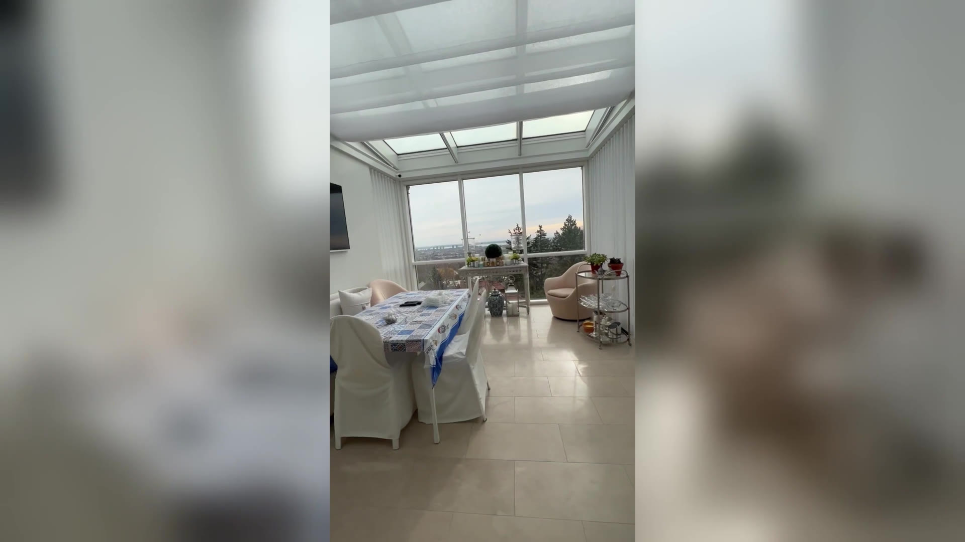 Motorized roman shade traveling across the skylight on Lutron Sivoia QS tracks