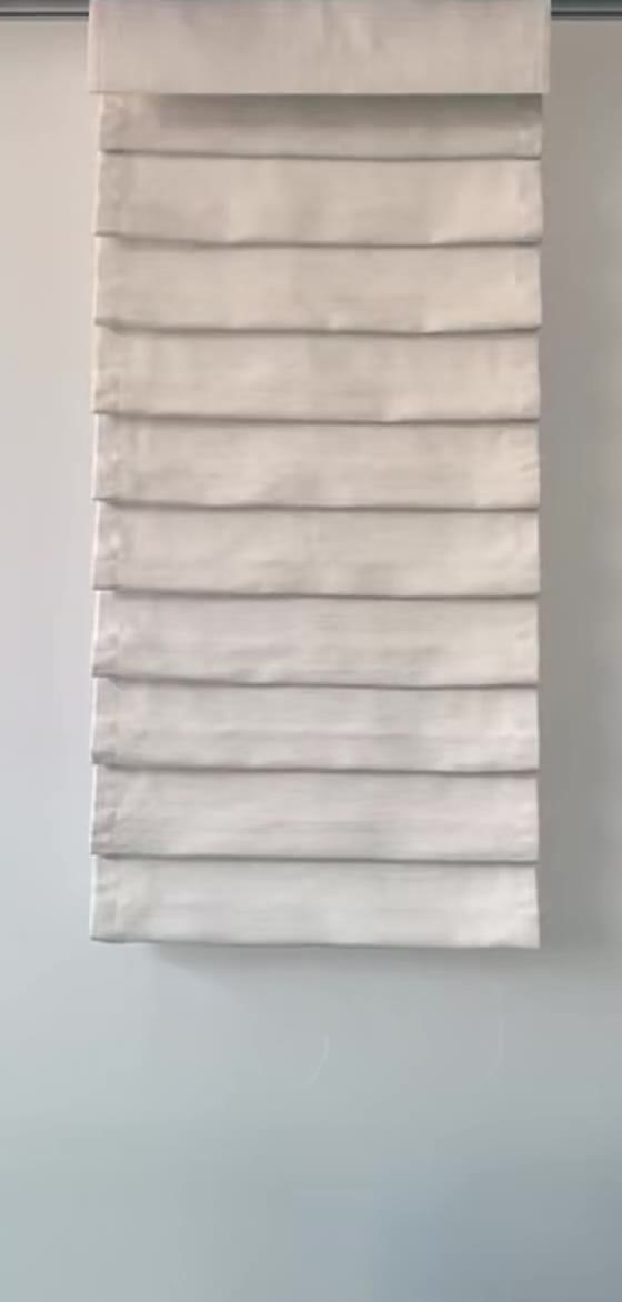 Motorized top-down bottom-up Roman shade fully lowered, hobbled folds covering the whole window