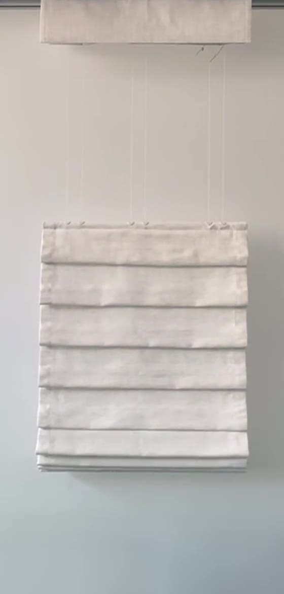 Top-down bottom-up Roman shade lowered from the top to halfway, open glass above the folded stack