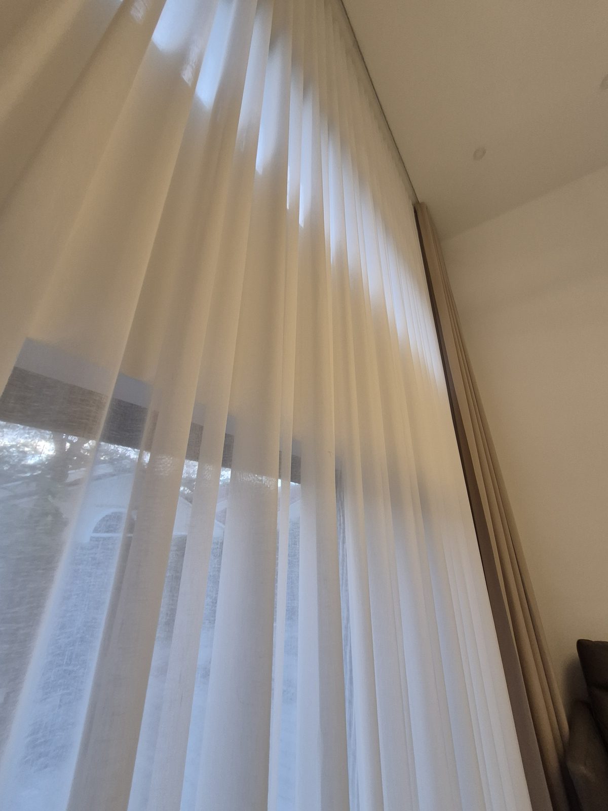 Looking up a two-story sheer, with the drapery stacked on its own track